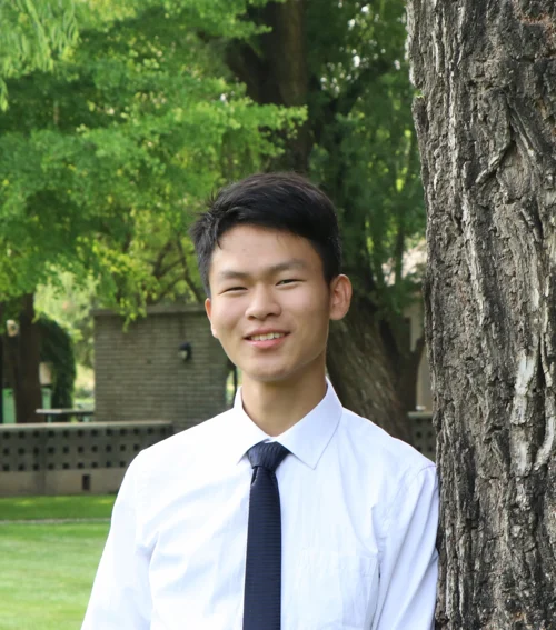 Jianping Jiang standing beside a tree
